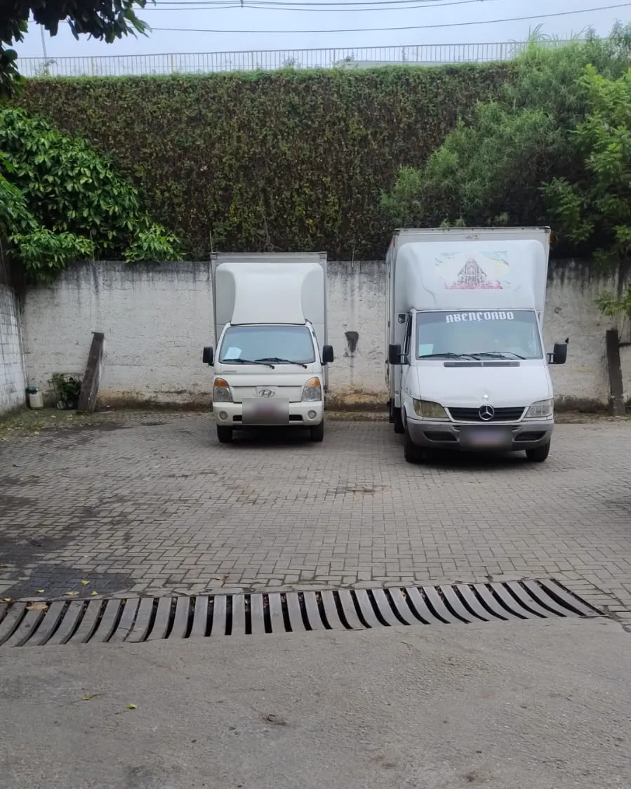 Dois caminhões baú estacionados lado a lado no pátio